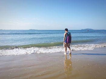 Full length of man walking at beach against sky