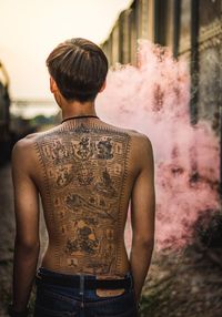 Rear view of shirtless man standing outdoors