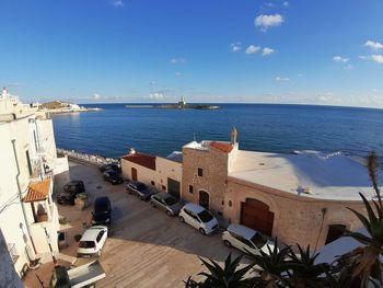 High angle view of buildings by sea against sky