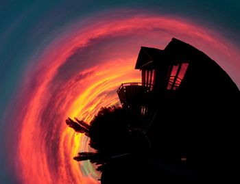 Silhouette built structure against sky at sunset