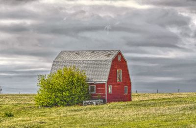 Barn on field against sky