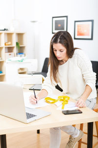 Young woman using phone while standing on table