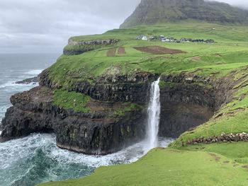 Scenic view of waterfall against sky