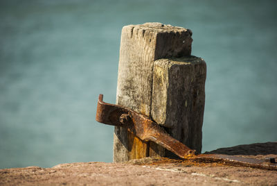 Close-up of rusty metallic structure by sea