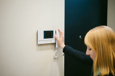 Close-up of woman holding telephone at home