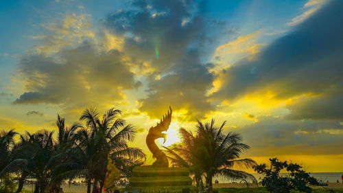 Silhouette palm trees against sky during sunset