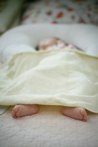 Baby girl sleeping while lying on bed at home