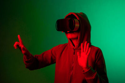 Side view of woman photographing against blue background