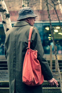 Rear view of man looking at camera