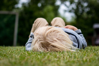 Baby boy lying on grassy field