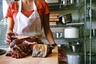 Woman preparing meet in kitchen