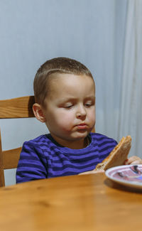 Portrait of cute boy sitting on table