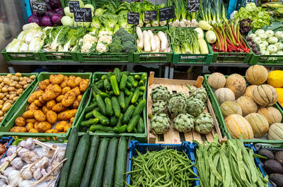 Different kinds of salad and vegetables for sale at a market