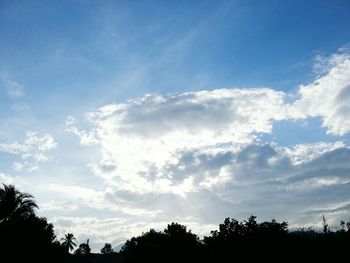 Low angle view of silhouette trees against cloudy sky