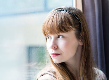 Close-up of woman looking through window