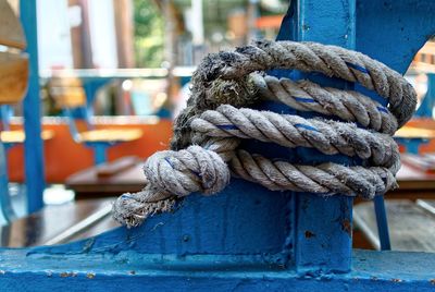 Close-up of rope tied on blue metal post