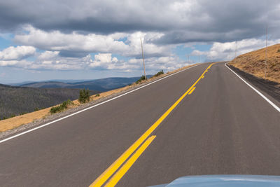 View of country road against cloudy sky