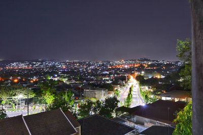 High angle view of illuminated cityscape against sky at night