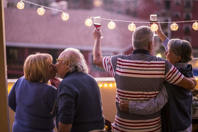 Senior couple standing in balcony during social gathering