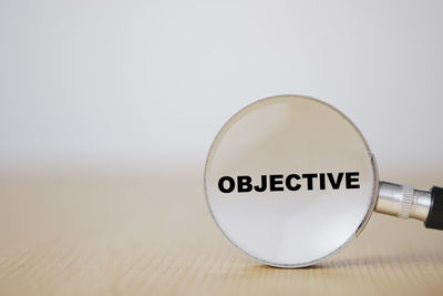 Close-up of information sign on table against white background