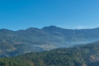 Scenic view of mountains against clear blue sky