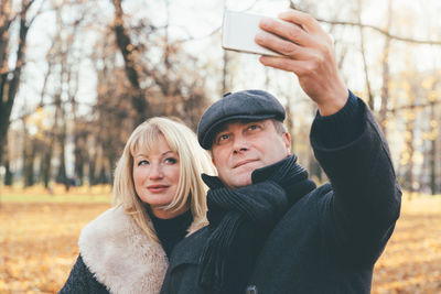 Mature couple taking selfie at park