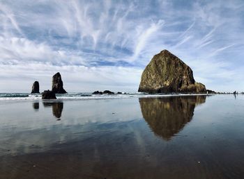 Rock formations on beach against sky