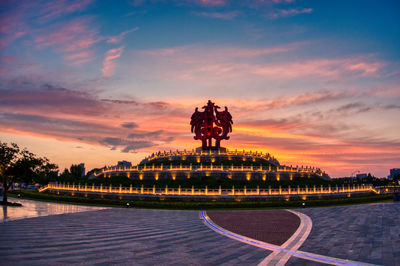 Sculpture in city during sunset