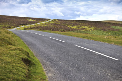 Empty road along countryside landscape