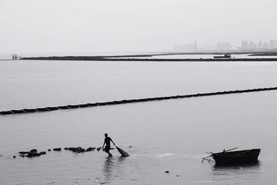 High angle view of fisherman walking in sea