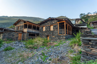 Old house by building against sky