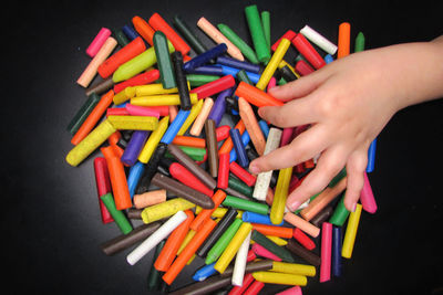 Low section of person holding multi colored candies