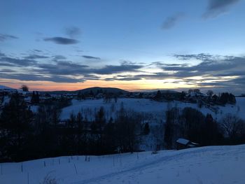 Scenic view of snow covered landscape against sky during sunset