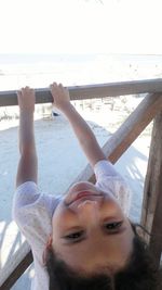 Young woman relaxing by sea against sky on sunny day