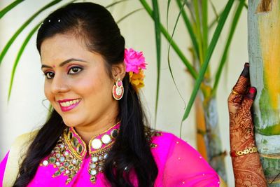 Smiling bride in traditional clothing looking away standing outdoors