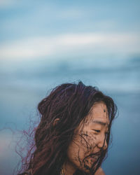 Portrait of woman against sea with sky in background