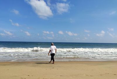 Full length of woman on beach against sky