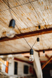 Low angle view of light bulb hanging from ceiling