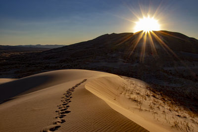 Scenic view of desert against sky during sunset