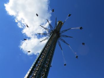 Low angle view of chain swing ride against blue sky