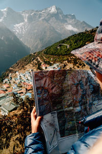 Midsection of person with umbrella in mountains