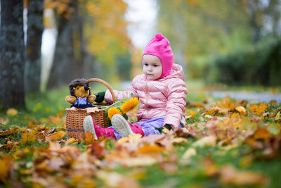 Cute baby girl sitting on field at park