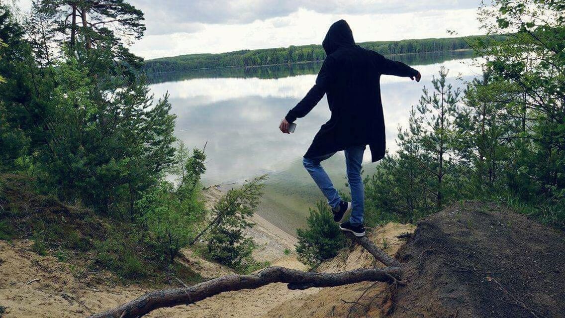 SILHOUETTE OF WOMAN JUMPING ON TREE TRUNK