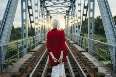 Rear view of woman walking on footbridge