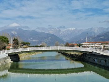 Arch bridge over lake against mountains