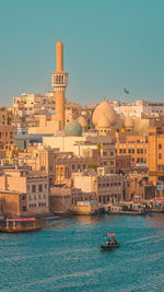 Buildings in city against clear blue sky