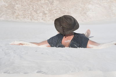 Man lying on snow covered land