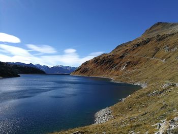 Scenic view of lake and mountains against blue sky