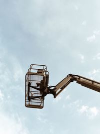 Low angle view of cherry picker against sky