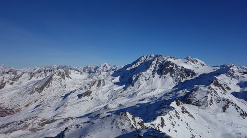 Scenic view of snowcapped mountains against blue sky